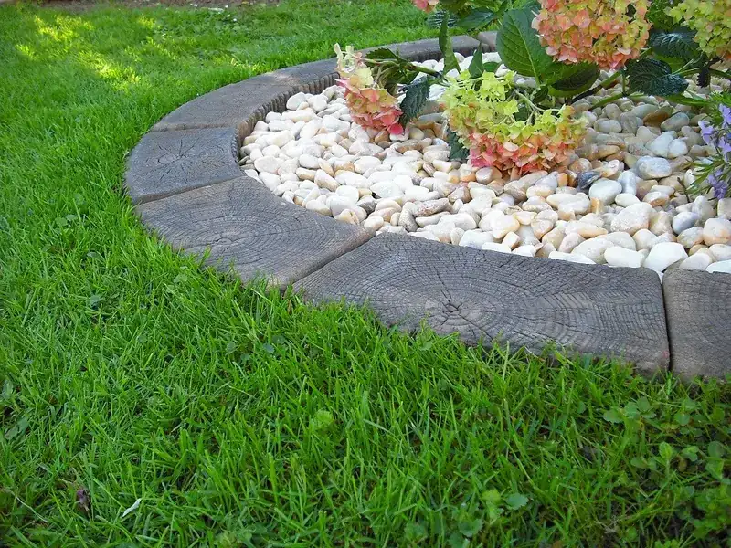 Curved stone border around a white-rock flower bed